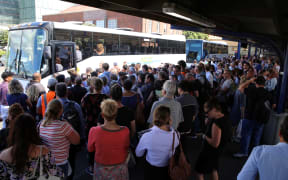Commuters in Wellington wait for buses after a power outage cut most train services out of the region.