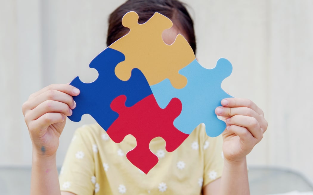 Kid girl hands holding puzzle jigsaw,  mental health concept, world autism awareness day