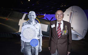 Ron Hermanns standing with a cut-out figure of his younger self at the Air Force Museum of New Zealand in 2019.