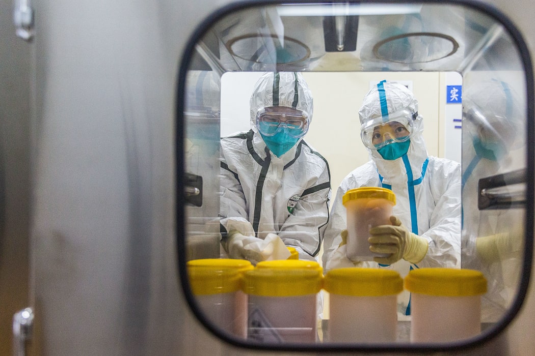 Staff members receive coronavirus strains for vaccine production delivered to the contagious disease prevention and control institution of the China Center for Disease Control on 25 February, 2020.