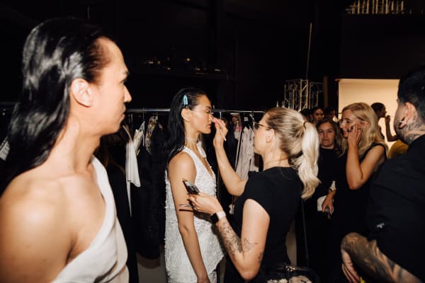 A makeup artist applies makeup to models.