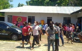 Villagers stand outside a building in Maumere in East Nusa Tenggara on Flores island after a 7.3-magnitude earthquake struck off the coast in eastern Indonesia.