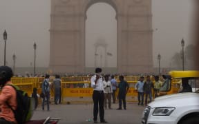 This photo taken on May 2, 2018 shows an Indian traffic policeman covering his face as he stands on duty during a dust storm in New Delhi.