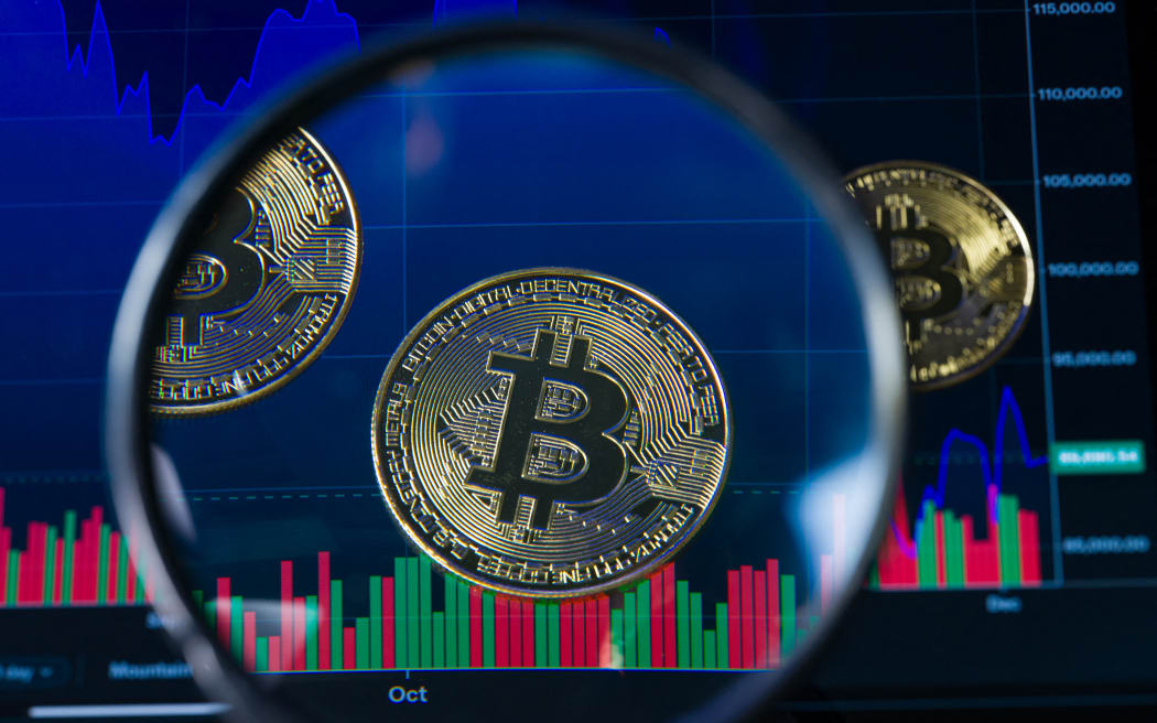 Tokens representing Bitcoin are placed on a screen showing a declining cryptocurrency chart, as Bitcoin trades around $89,635 against the U.S. dollar, in this photo illustration in Brussels, Belgium, on December 6, 2025. (Photo by Jonathan Raa/NurPhoto) (Photo by Jonathan Raa / NurPhoto via AFP)