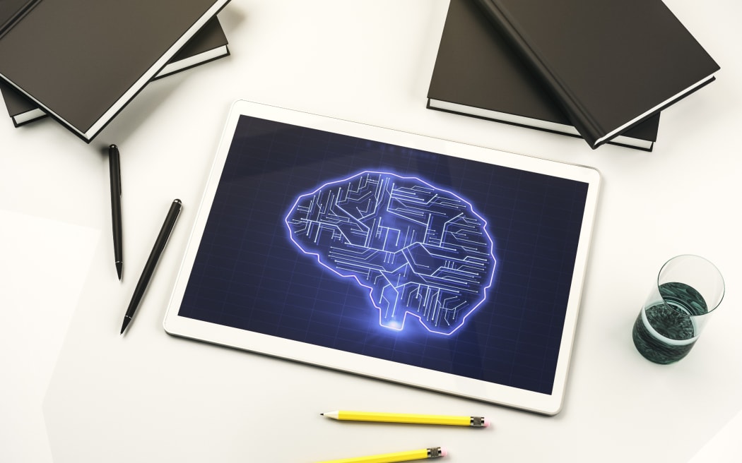 A design signifying artificial intelligence, with an image of a brain styled like a circuit board on a tablet, surrounded by writing implements and notebooks.