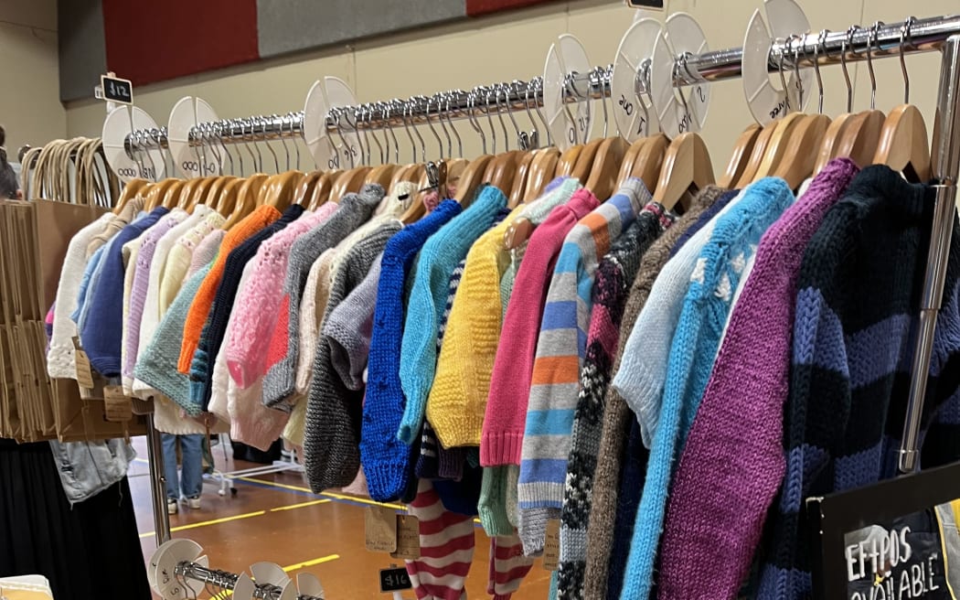 A stall with hanged clothes on rails at Gently Loved's just kids market.