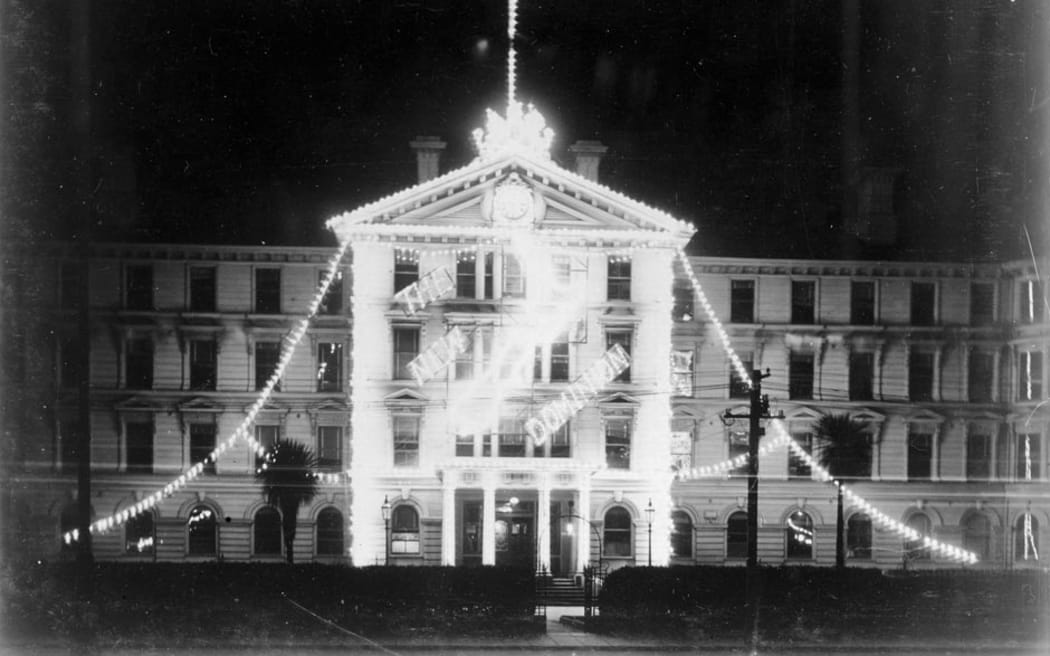 Government Buildings on Lambton Quay, Wellington, are illuminated for Dominion Day (26 September) in 1907.