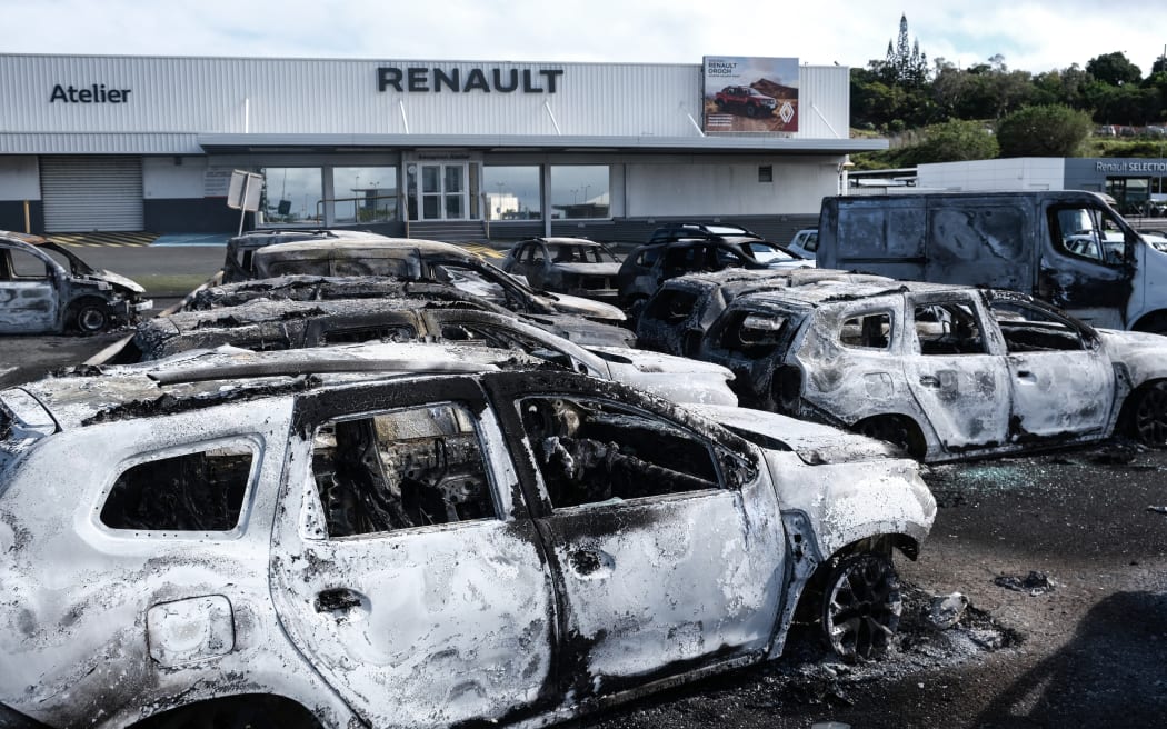 Burnt cars are pictured at a car dealer store in the Magenta district in Noumea on May 14, 2024, amid protests linked to a debate on a constitutional bill aimed at enlarging the electorate for upcoming elections of the overseas French territory of New Caledonia.