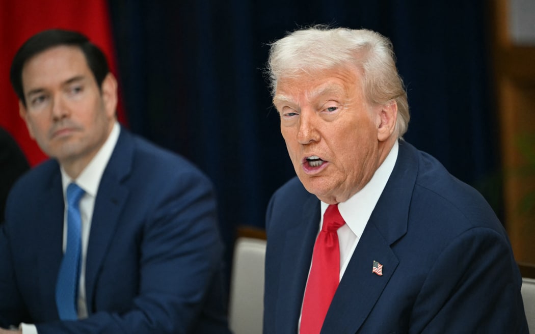 US Secretary of State Marco Rubio (L) looks on as US President Donald Trump speaks during his meeting with China's President Xi Jinping at the Gimhae Air Base, located next to the Gimhae International Airport in Busan on October 30, 2025. Donald Trump and Chinese leader Xi Jinping will seek a truce in their bruising trade war on October 30, with the US president predicting a "great meeting" but Beijing being more circumspect. (Photo by ANDREW CABALLERO-REYNOLDS / AFP)