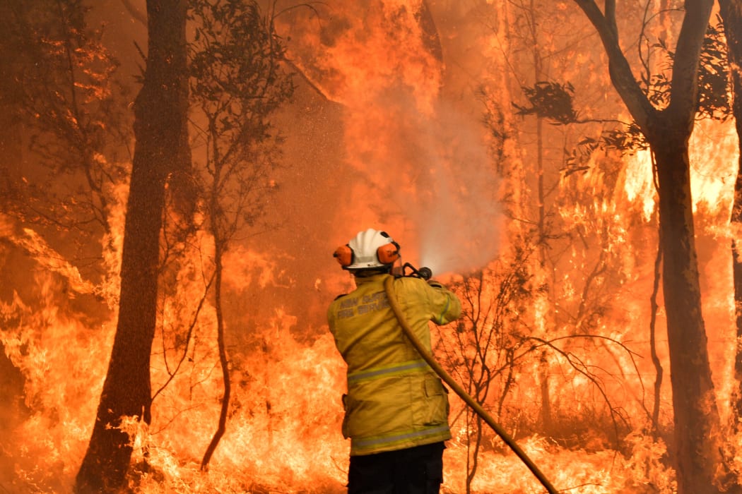A firefighter conducts back-burning measures to secure residential areas from encroaching bushfires in the Central Coast, some 90-110 kilometres north of Sydney on December 10, 2019.