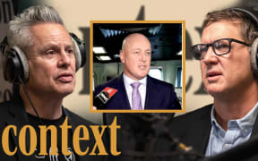 Guyon Espiner is wearing headphones positioned on the left of the image looking to the right. Corin Dann is wearing headphones on the right of the image looking towards the left. In the middle of the image is a yellow square featuring a picture of Prime Minister Christopher Luxon. In the bottom left hand corner is the logo for the podcast series 'Context' in mustard yellow.