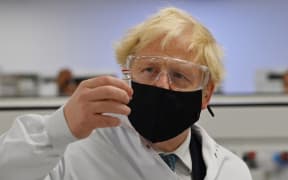 Britain's Prime Minister Boris Johnson poses for a photograph with a vial of the AstraZeneca/Oxford University COVID-19 candidate vaccine, known as AZD1222, at Wockhardt's pharmaceutical manufacturing facility in Wrexham, north Wales, on November 30, 2020.