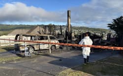 The aftermath of a fire in Spur Grove, Tītahi Bay, Porirua, on 21 June 2026, which badly damaged a house and a caravan on neighbouring properties the night before.
