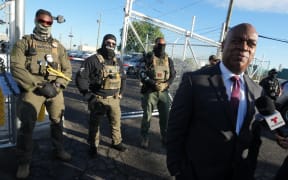 Mayor Ras Baraka of Newark speaks to the press near ICE agents at a demonstration outside an immigrant detention centre in Elizabeth, New Jersey May 7, 2025. The Mayor arrived at the gates of Delaney Hall to inspect the previously vacant prison that is being converted into an immigrant detention center. Delaney Hall has the ability to hold over a 1000 people, and the detention facility, privately owned by The GEO Group, holds a contract with the federal government to house people arrested by ICE. (Photo by TIMOTHY A. CLARY / AFP)