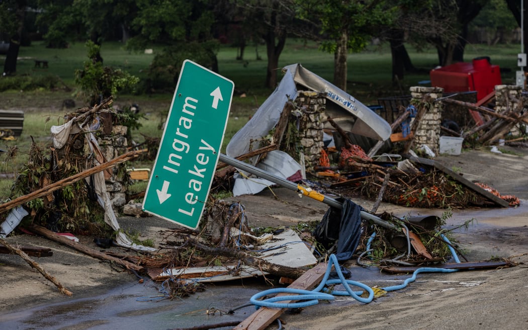 HUNT, TEXAS - JULY 6: A road sign lays among debris after flash flooding tore through the area on July 6, 2025 in Hunt, Texas. Heavy rainfall caused flooding along the Guadalupe River in central Texas with multiple fatalities reported.   Jim Vondruska/Getty Images/AFP (Photo by Jim Vondruska / GETTY IMAGES NORTH AMERICA / Getty Images via AFP)