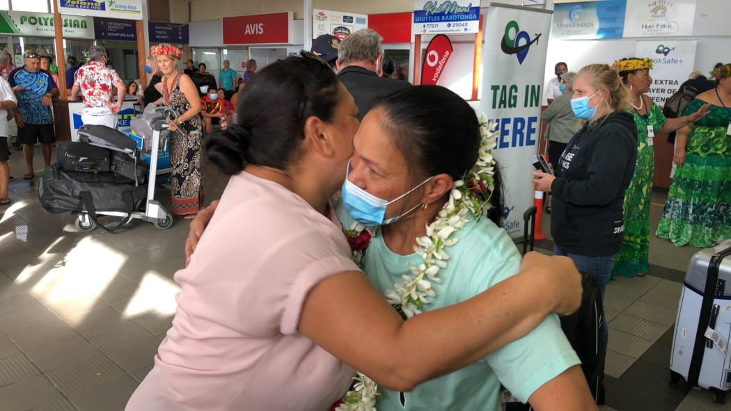 People greet each other in the Cook Islands on the first day of the travel bubble with New Zealand.
