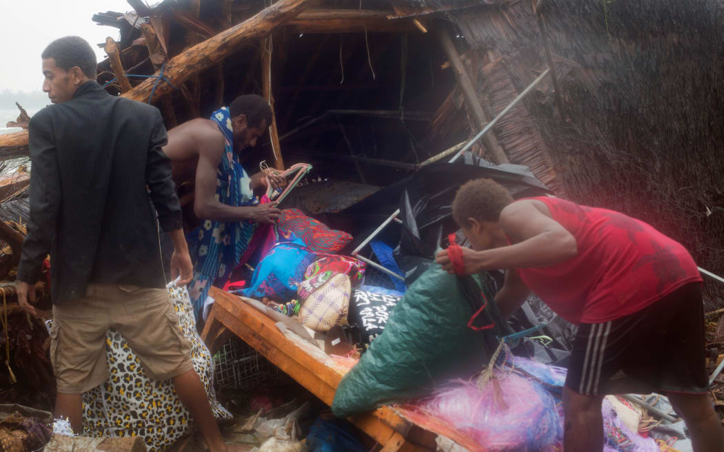 Residents in Port Vila looking through storm damage caused by Cyclone Pam.