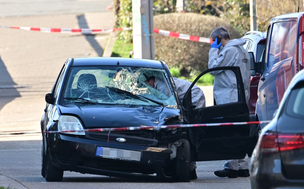 Forensic officers examine a damaged car at the site of a car ramming attack in Mannheim, southwestern Germany on March 3, 2025.