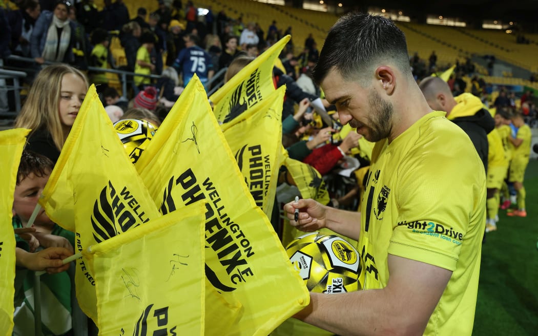 Phoenix player Tim Payne signs autographs for young fans at Sky Stadium in Wellington. 2021.