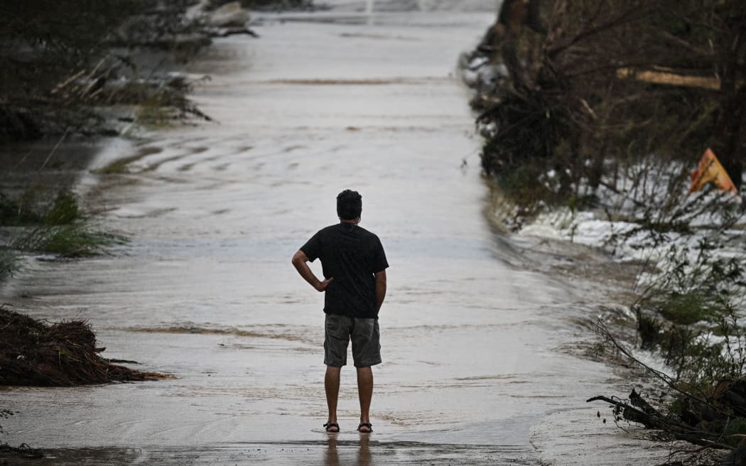 A man looks at a damaged road after severe flash flooding that occurred during the July 4 holiday weekend, in Hunt, Texas, on July 6.