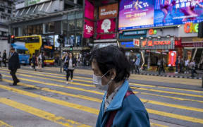 A Women wears a mask as she crosses a road in Tsim Sha Tusi District on January 22, 2019 in Hong Kong, China.
