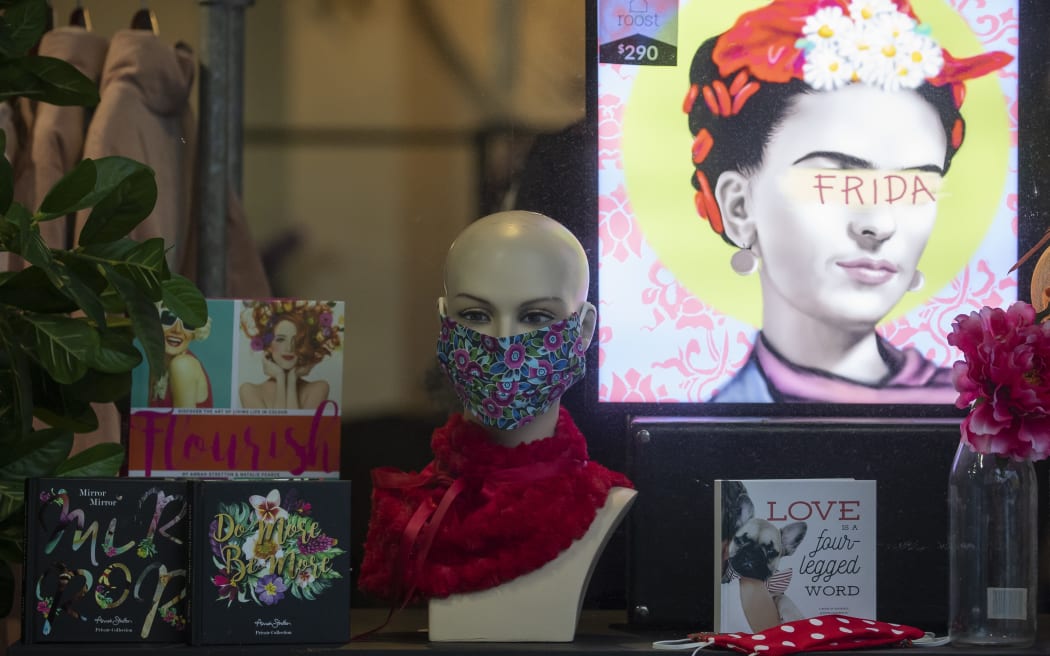 A mannequin with a protective face mask is seen in front of a fashion store display in Christchurch, New Zealand, on April 30, 2020.