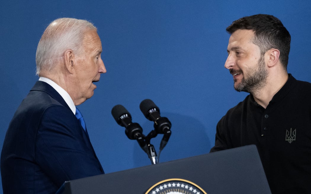 Ukraine's President Volodymyr Zelensky (R) reacts after being introduced as Russia's President Vladimir Putin by US President Joe Biden during a Ukraine Compact event on the sidelines of the NATO members meeting at the Washington Convention Center July 11, 2024, in Washington, DC. (Photo by Brendan Smialowski / AFP)