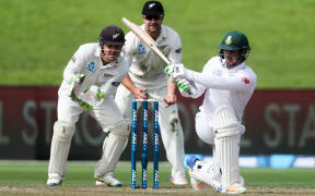 Quintin de Kock sweeps as BJ Watling and Colin de Grandhomme look on.
