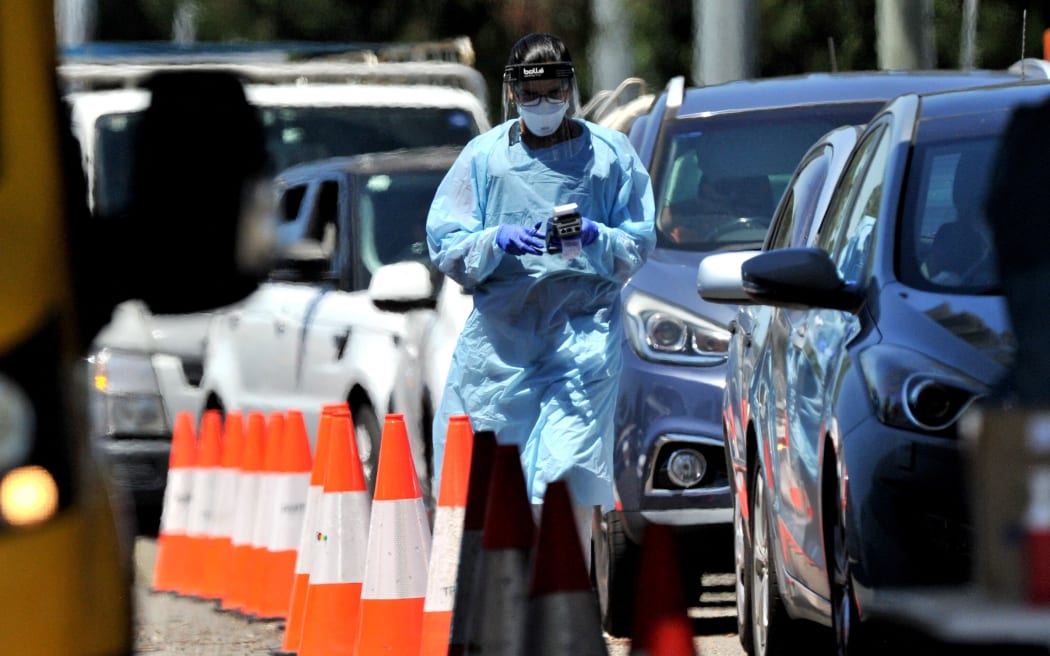 A medical worker performs a PCR test at a drive-through Covid-19 test centre in western Sydney on December 21, 2021. (Photo by Mohammad FAROOQ / AFP)