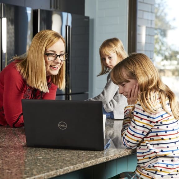 Dr Catherine Page Jeffery with two children, looking at a laptop