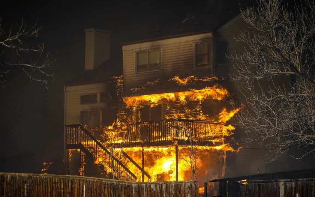 LOUISVILLE, CO - DECEMBER 30: A home burns after a fast moving wildfire swept through the area in the Centennial Heights neighborhood on December 30, 2021 of Louisville, Colorado.
