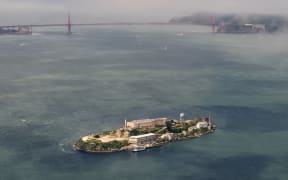 An aerial view shows Alcatraz island in front of the Golden Gate Bridge in San Francisco, California. Initially a federal prison before being converted into a tourist, it had  been one of the most notorious jails in American history.