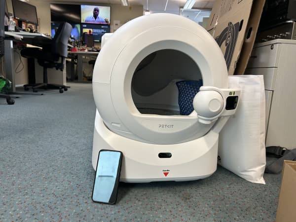 A smart litter box compared to a phone for sizing