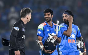 India's Washington Sundar (C) speaks with New Zealand's captain Michael Bracewell (L) as his teammate KL Rahul watches at the end of the first one-day international (ODI) cricket match between India and New Zealand at the Kotambi Stadium in Vadodara on January 11, 2026. (Photo by Shammi MEHRA / AFP) / -- IMAGE RESTRICTED TO EDITORIAL USE - STRICTLY NO COMMERCIAL USE --