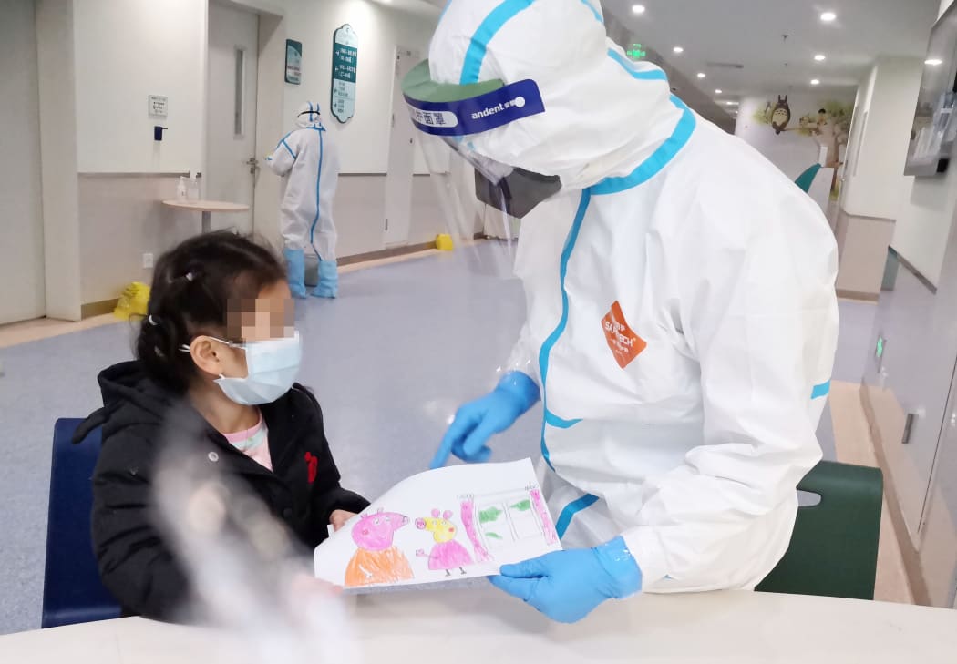 A nurse Yang Liu receiving a painting as a gift from a child infected with novel coronavirus pneumonia at a ward in Wuhan Children's Hospital in Wuhan.
