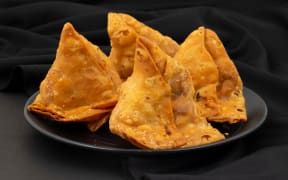 Indian Street Food Samosa or Samosas is a Crispy And Spicy Triangle Shape Snack Which Has Crisp Outer Layer of Maida & Filling of Mashed Potato, Peas And Spices. Served With Chutney, Ketchup or Curd