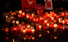 candles lie on the ground at the Christmas market on Breitscheidplatz square in Berlin, Germany, 22 December 2016.