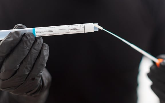 Covid-19 respiratory sputum specimen swab test tube with gloves.