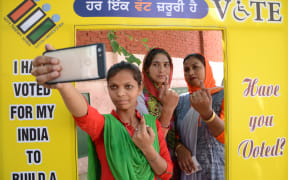 Indian voters pose for a picture with their ink-marked fingers after casting votes at a polling centre on the outskirts of Amritsar.