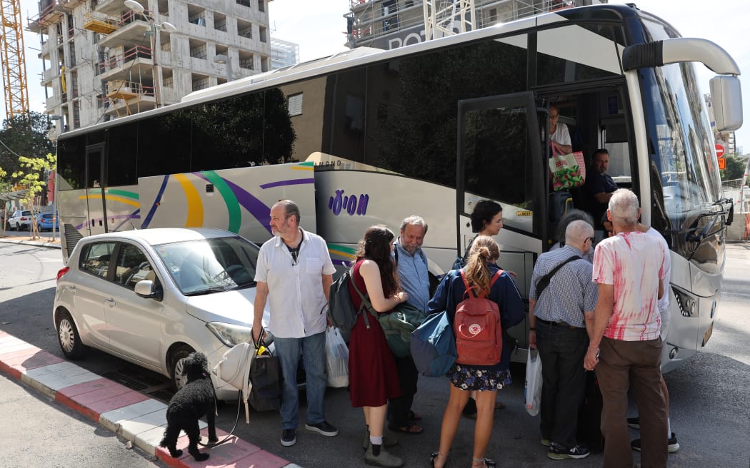 Residents queue to board a coach transporting them to a hotel in Tel Aviv on October 7, 2023, after a barrage of rockets were fired and fighters from the Gaza Strip infiltrated Israel, a major escalation in the Israeli-Palestinian conflict. (Photo by JACK GUEZ / AFP)