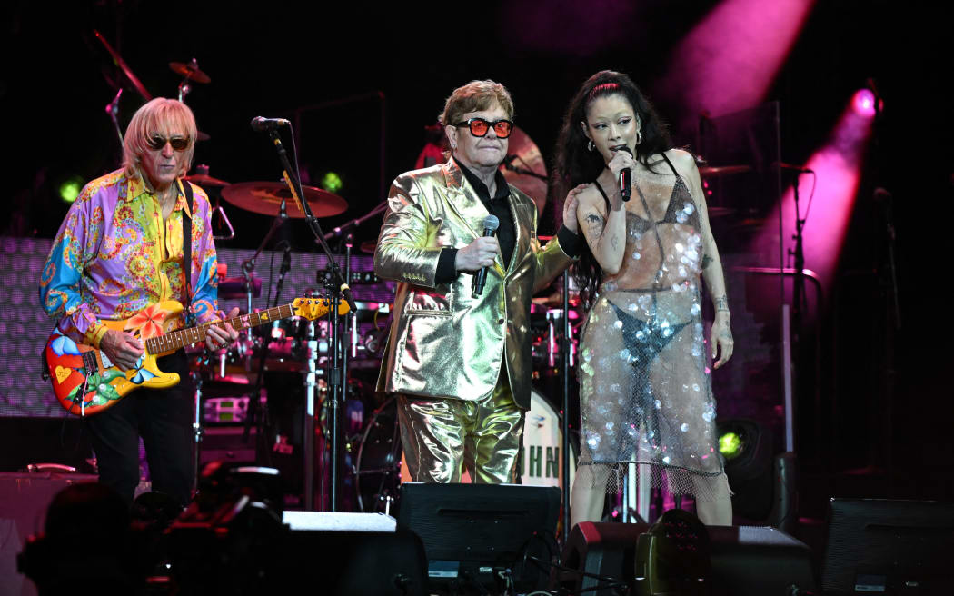British legendary singer Elton John (C) performs with Rina Sawayama (R) on the Pyramid Stage on day 5 of the Glastonbury festival in the village of Pilton in Somerset, southwest England, on June 25, 2023. Elton John closes out Britain's legendary Glastonbury Festival on Sunday in what has been billed as his final UK performance. The 76-year-old pop superstar is winding down a glittering live career with a global farewell tour, having played his last concerts in the United States in May ahead of a final gig in Stockholm on July 8. (Photo by Oli SCARFF / AFP)