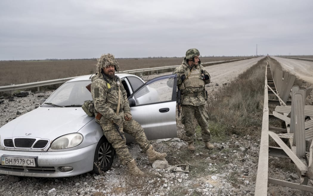 Ukrainian soldiers stand guard on the road from Mykolaiv to Kherson.