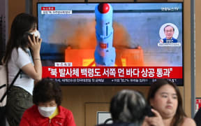 People watch a television screen showing a news broadcast with file footage of North Korea's rocket launch, at the Seoul Railway Station in Seoul on 31 May, 2023.