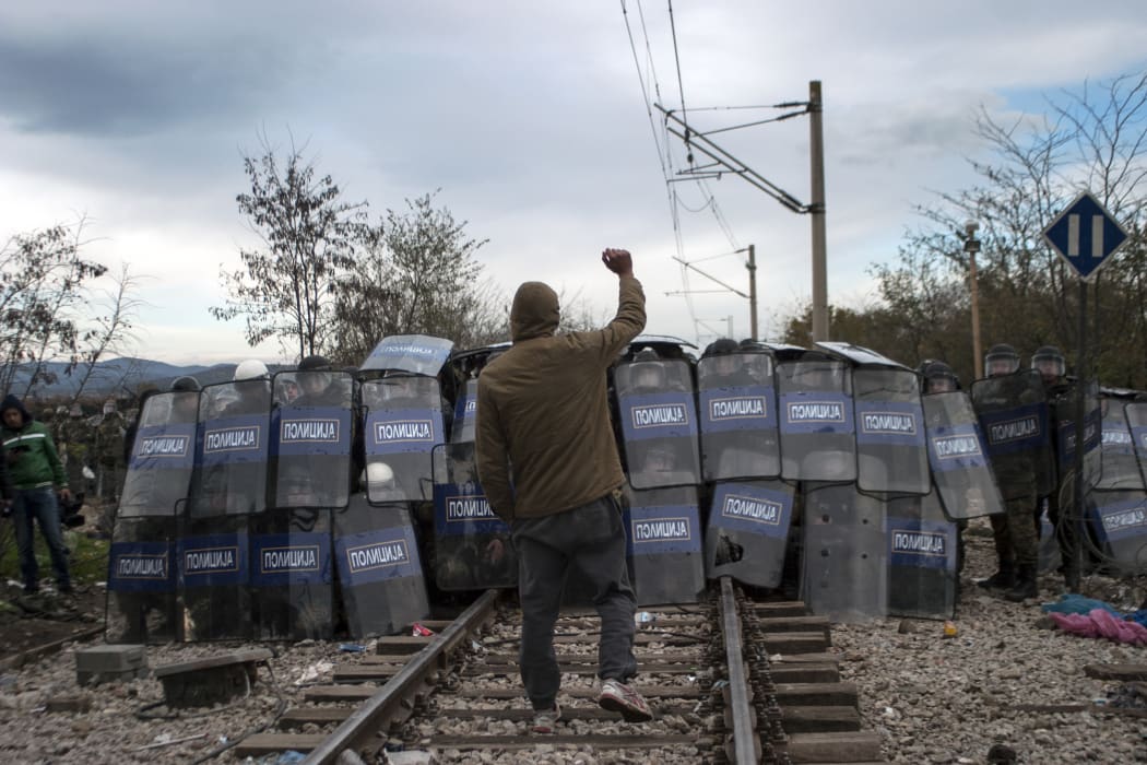 Macedonian police cordon during clashes with refugees protesting against the building of a metal fence at the Greek-Macedonian border