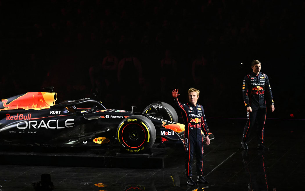 Red Bull Racing's Dutch driver Max Verstappen (R) and Red Bull Racing's New Zealand driver Liam Lawson stand by the new Formula 1 car at the 2025 season launch in London.