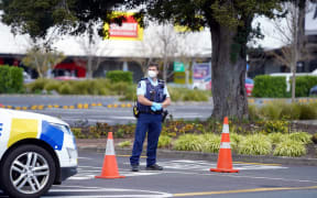 Police keep watch outside the Countdown supermarket at Lynn Mall in Auckland on September 4, 2021, the day after an IS-inspired attacker injured six people in a knife rampage before being shot dead by undercover police.