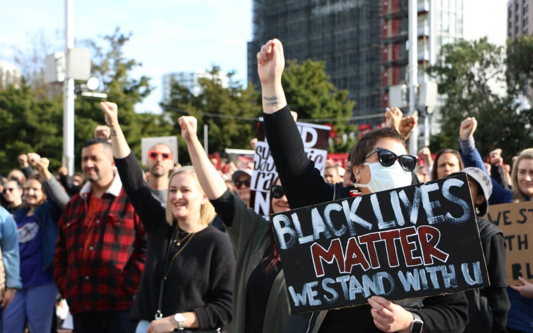 Protesters raise their fists to show solidarity at the Black Lives Matter march in Auckland on 14 June, 2020.