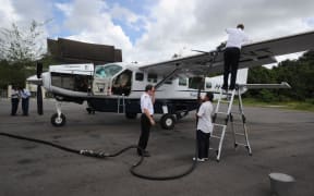 n this photograph taken on July 5, 2011 two Susi Air pilots (R and 2nd R) refuel a Cessna Grand Caravan aircraft in Pangkalanbun, Central Kalimantan province.