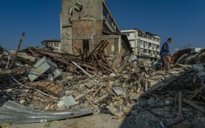 A man walks in the ruins of the city center of Antakya, destroyed after the massive earthquake in southern Turkey. (Photo by Celestino Arce/NurPhoto) (Photo by Celestino Arce / NurPhoto / NurPhoto via AFP)