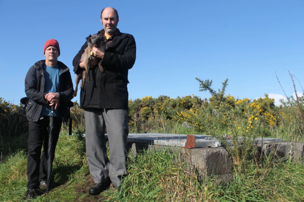 An image of filmmaker Paul Janman and author Scott Hamilton stand by the entrance to the cave.